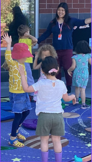 Preschoolers listening to a story out on the balcony.
